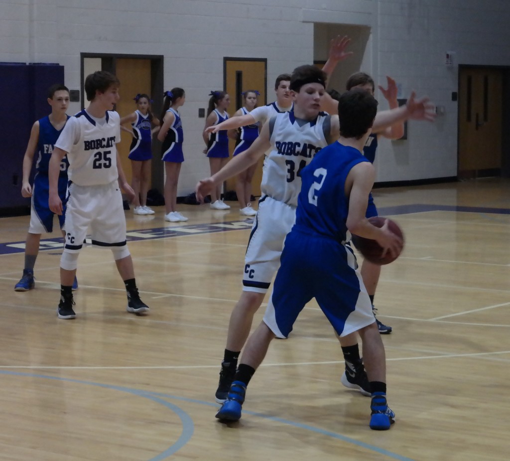 Clear Creek eighth-grader Connor Thompson prevents Fannin Rebel Carson Beavers from getting an open look. Thompson led the Bobcats with 13 points in Clear Creek's 33-26 victory over Fannin yesterday. (Photo by: Kevin Hensley)