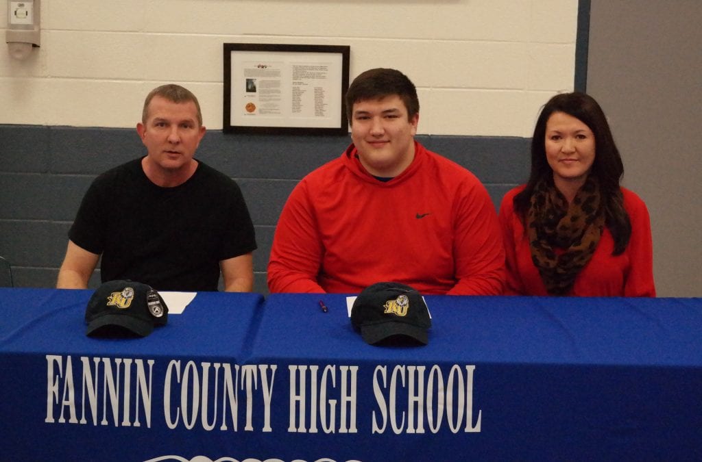 Tyler Jones is seated with his parents Wesley (left) and Mary (right) Jones. Tyler committed to play college football for the Reinhardt University Eagles yesterday, during a ceremony held at Fannin County High School. (Photo by: Kevin Hensley).