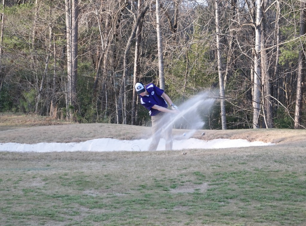 Bobcat Tyler Queen blasts his way out a fairway bunker, during a match against Southeast Whitfield last Wednesday. Queen led the Bobcats during a tri-match at Dawson against the Tigers and Fannin by shooting a 45. (Photo by: Kevin Hensley)