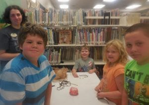 Christa Edmonds helps children make a key-chain. At the end of each story time, the kids make a craft that goes with the story themes.