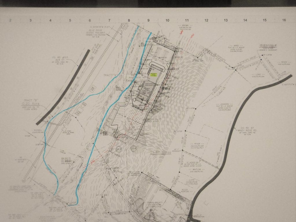 The blue line represents the 100 year flood plain. After grading and construction, the facility will sit several feet above the flood plain.