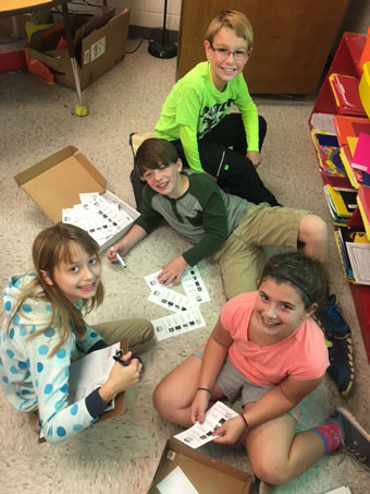 4th grade students recording and analyzing West Fannin Presidential Mock Election results. Mason McDaniel (bright green), Bryce Mitchell (dark green), Hope Hill (blue and white jacket), Julie Farmer (orange)
