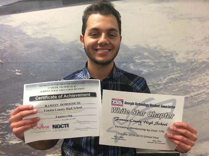 Ramtin Doroodchi holding his NOCTI Engineering Certificate and the TSA White Star Chapter Award